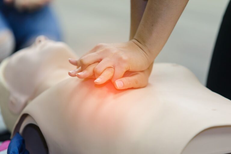 A lady practicing cpr on a mannequin.