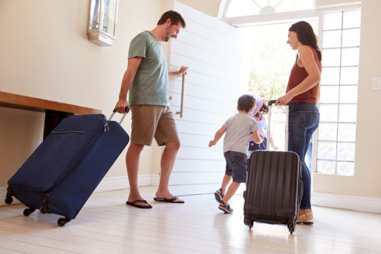 Family leaving their home with luggage to go on vacation